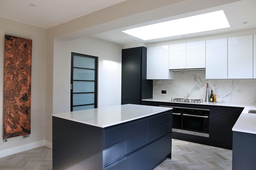 Modern inredning av ett kök, med släta luckor, blå skåp, bänkskiva i kvartsit, vitt stänkskydd, stänkskydd i marmor och en köksö