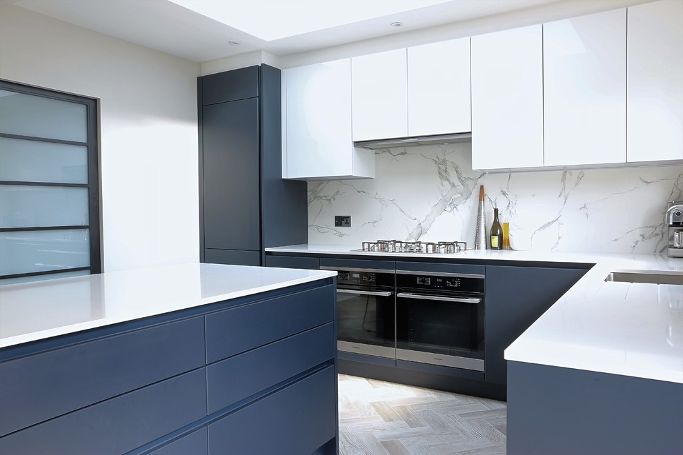 Foto på ett funkis kök, med släta luckor, blå skåp, bänkskiva i kvartsit, vitt stänkskydd, stänkskydd i marmor och en köksö
