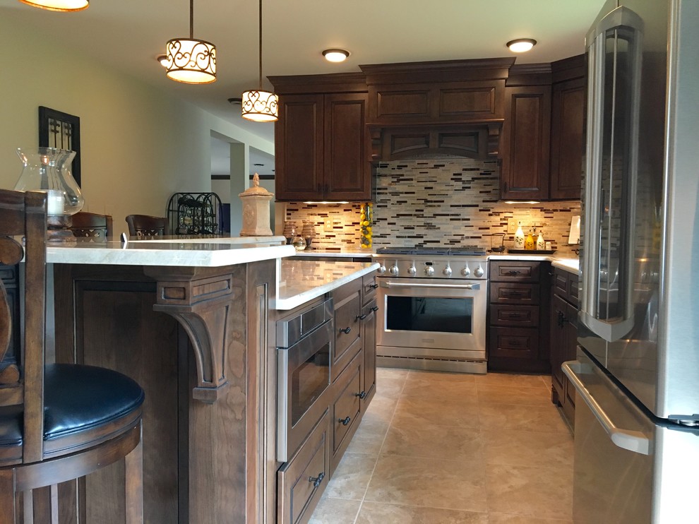Eat-in kitchen - mid-sized traditional l-shaped ceramic tile eat-in kitchen idea in New York with raised-panel cabinets, dark wood cabinets, stainless steel appliances, an island, an undermount sink, beige backsplash and matchstick tile backsplash