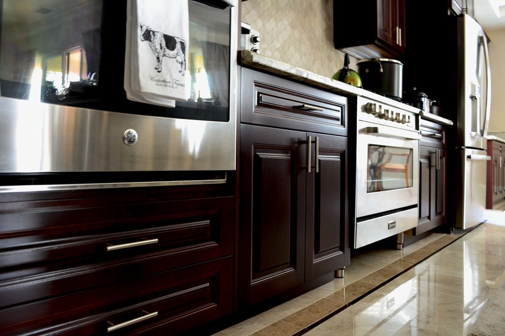 Moderne Wohnküche in L-Form mit profilierten Schrankfronten, hellbraunen Holzschränken, Granit-Arbeitsplatte, Küchenrückwand in Weiß, Küchengeräten aus Edelstahl, Linoleum und Kücheninsel in Los Angeles