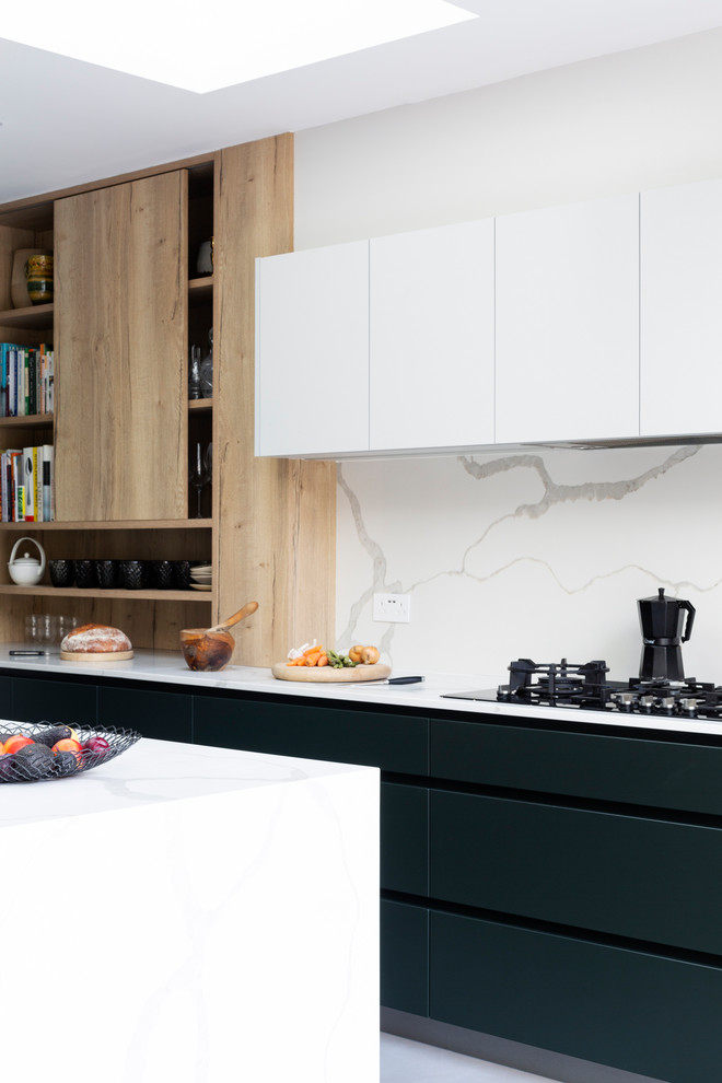Design ideas for a medium sized contemporary l-shaped open plan kitchen in London with an integrated sink, flat-panel cabinets, green cabinets, composite countertops, white splashback, marble splashback, stainless steel appliances, porcelain flooring, an island, grey floors and white worktops.