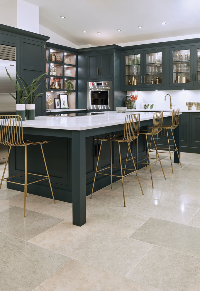 Example of a mid-sized transitional l-shaped marble floor and beige floor eat-in kitchen design in London with a drop-in sink, shaker cabinets, green cabinets, quartzite countertops, white backsplash, stainless steel appliances, an island and white countertops