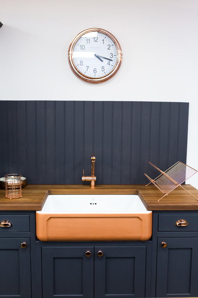 Imagen de cocina lineal tradicional renovada pequeña con armarios estilo shaker, encimera de madera, salpicadero de madera, fregadero sobremueble, puertas de armario azules, salpicadero azul y encimeras marrones