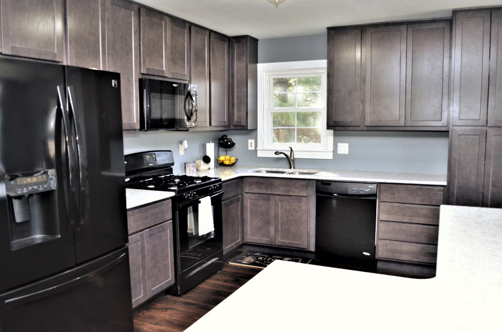 Immagine di una cucina classica di medie dimensioni con lavello sottopiano, ante in stile shaker, ante grigie, top in quarzite, elettrodomestici neri, pavimento in laminato, pavimento marrone e top bianco