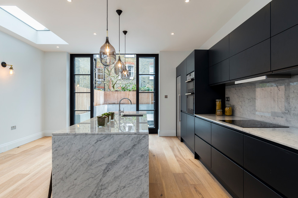 Eat-in kitchen - mid-sized modern galley eat-in kitchen idea in London with gray cabinets and an island