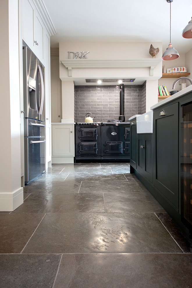 Photo of a medium sized farmhouse u-shaped kitchen in Other with limestone flooring, an island and green floors.