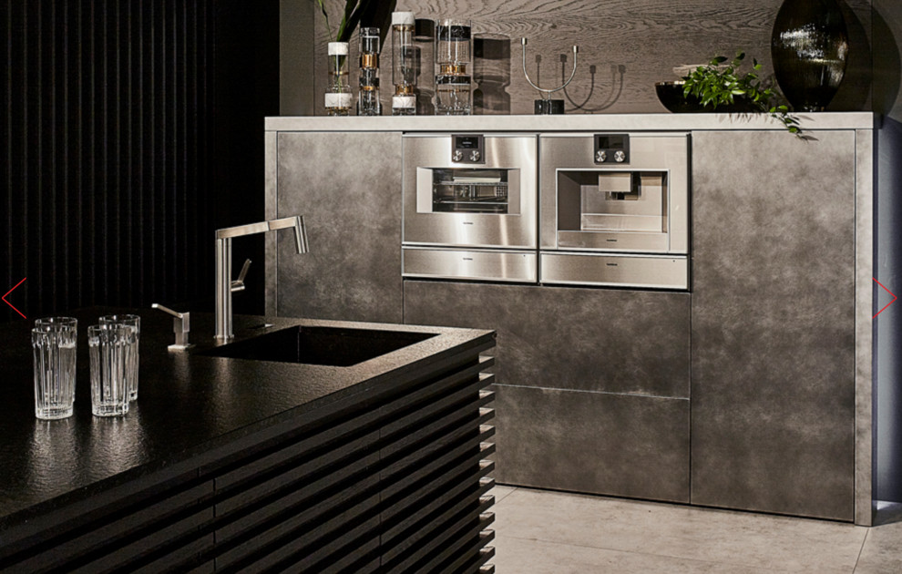 Inspiration för stora moderna svart kök, med en dubbel diskho, släta luckor, bänkskiva i betong, svart stänkskydd, stänkskydd i cementkakel, integrerade vitvaror, ljust trägolv, en köksö och brunt golv