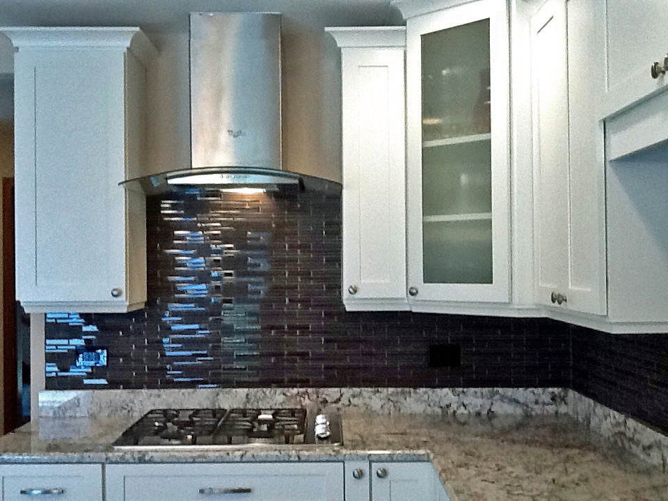 Immagine di una cucina abitabile chic con ante in stile shaker, ante bianche, paraspruzzi con piastrelle a mosaico, nessuna isola, top in granito e elettrodomestici in acciaio inossidabile