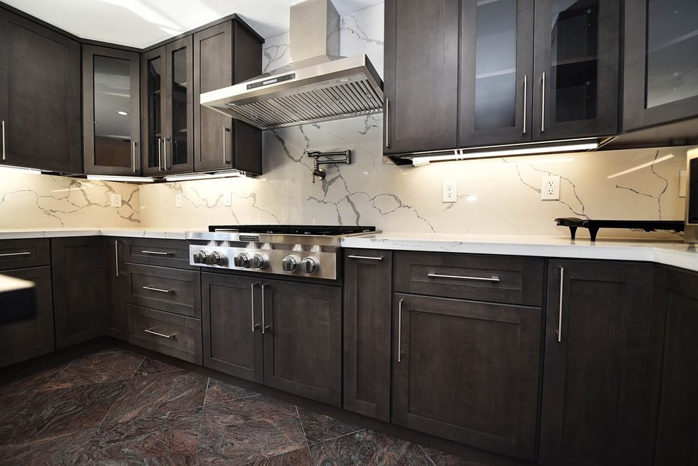 Example of a mid-sized minimalist u-shaped porcelain tile and brown floor kitchen design in San Francisco with a farmhouse sink, shaker cabinets, dark wood cabinets, quartzite countertops, white backsplash, stainless steel appliances, an island and white countertops