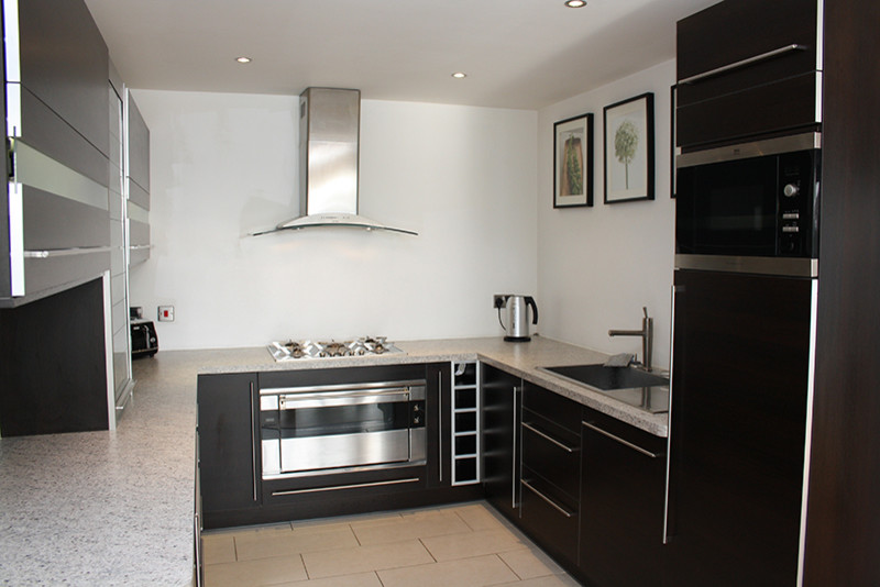 Пример оригинального дизайна: п-образная кухня-гостиная среднего размера в стиле модернизм с черными фасадами