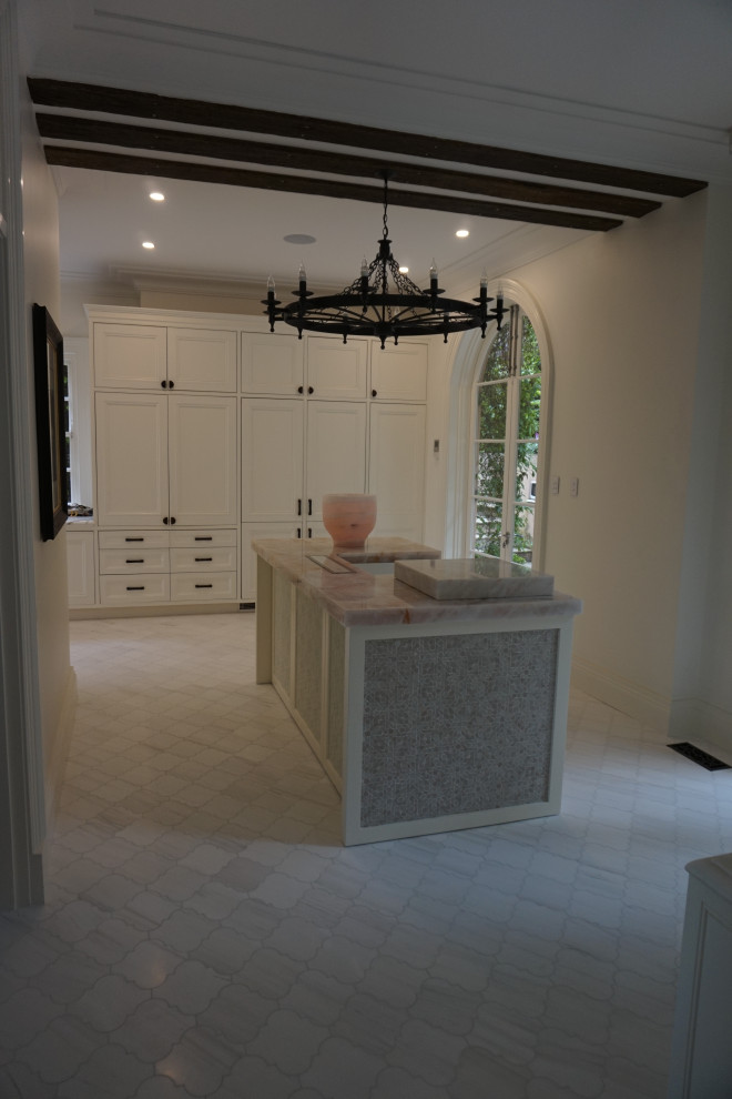 Exemple d'une cuisine méditerranéenne avec un placard à porte shaker, des portes de placard blanches, plan de travail en marbre, un électroménager blanc, un sol en carrelage de porcelaine, îlot, un sol multicolore et un plan de travail rose.