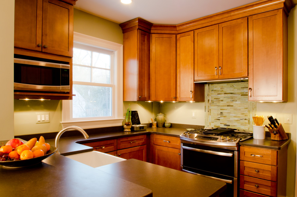 Exempel på ett litet amerikanskt kök, med en rustik diskho, skåp i shakerstil, skåp i mellenmörkt trä, bänkskiva i kvarts, grönt stänkskydd, stänkskydd i glaskakel, rostfria vitvaror, mellanmörkt trägolv och en halv köksö