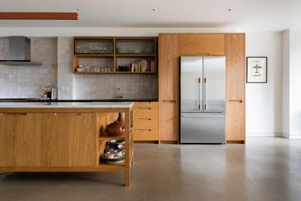 Inspiration for a large contemporary l-shaped concrete floor and gray floor eat-in kitchen remodel in London with a single-bowl sink, flat-panel cabinets, medium tone wood cabinets, marble countertops, white backsplash, mosaic tile backsplash, stainless steel appliances, an island and white countertops