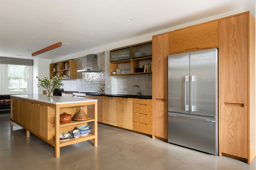 This is an example of a large contemporary l-shaped kitchen/diner in London with a single-bowl sink, flat-panel cabinets, medium wood cabinets, marble worktops, white splashback, mosaic tiled splashback, stainless steel appliances, concrete flooring, an island, grey floors and white worktops.