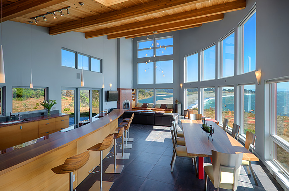 На фото: большая прямая кухня-гостиная в морском стиле с монолитной мойкой, плоскими фасадами, фасадами цвета дерева среднего тона, серым фартуком и островом