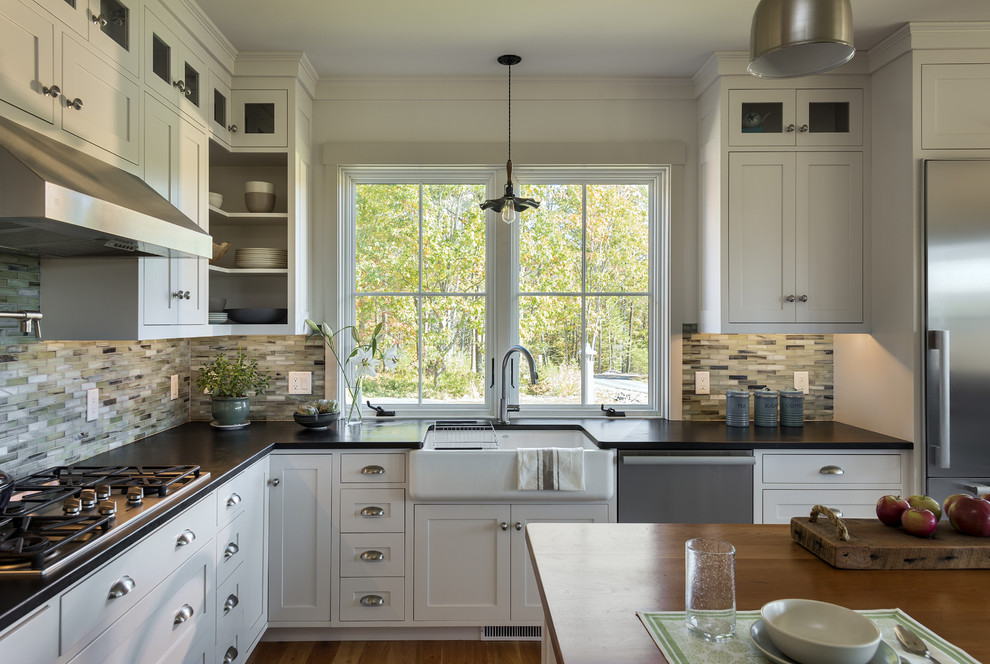 Mittelgroße Klassische Wohnküche in L-Form mit Waschbecken, Schrankfronten im Shaker-Stil, weißen Schränken, bunter Rückwand, Rückwand aus Glasfliesen, Küchengeräten aus Edelstahl, braunem Holzboden und Kücheninsel in Portland Maine