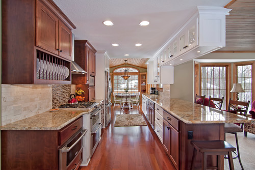 Traditional kitchen with engineered wood flooring, granite countertops, and wooden cabinetry in a bright open layout