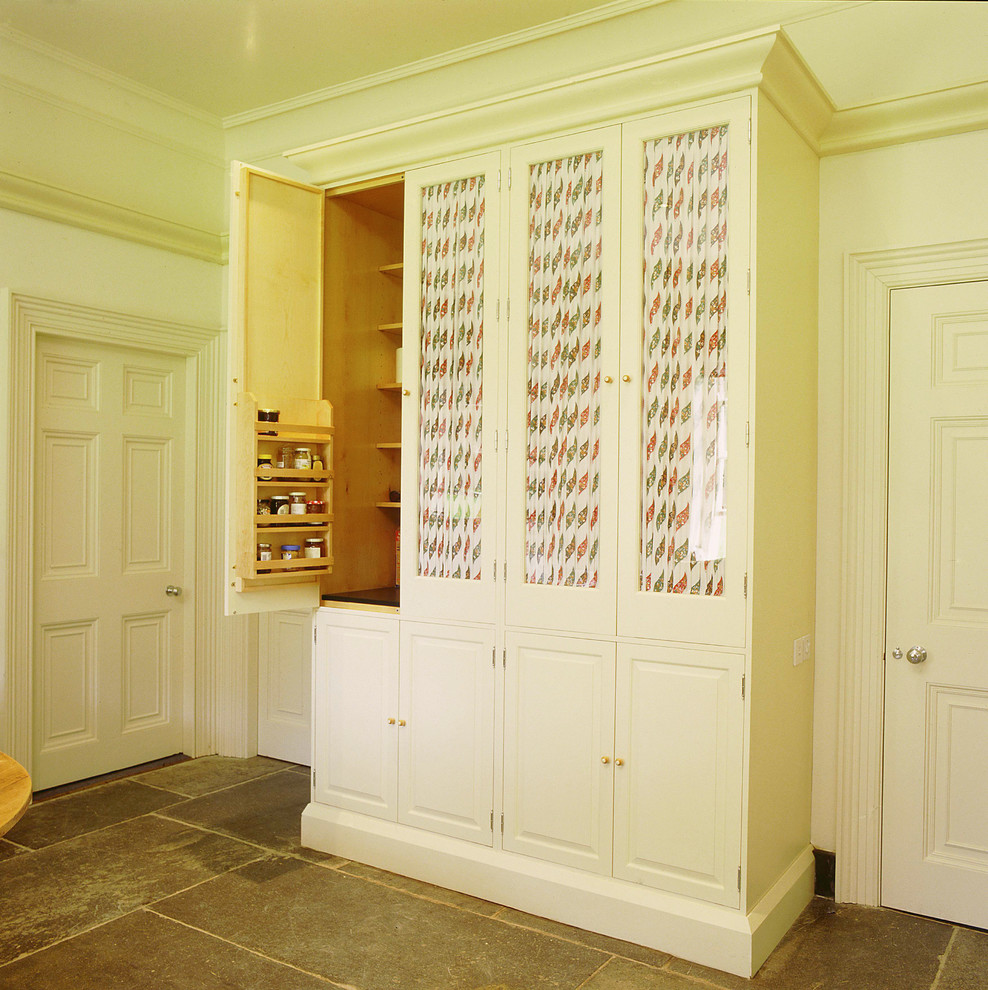 Cette photo montre une cuisine chic avec des portes de placard blanches.