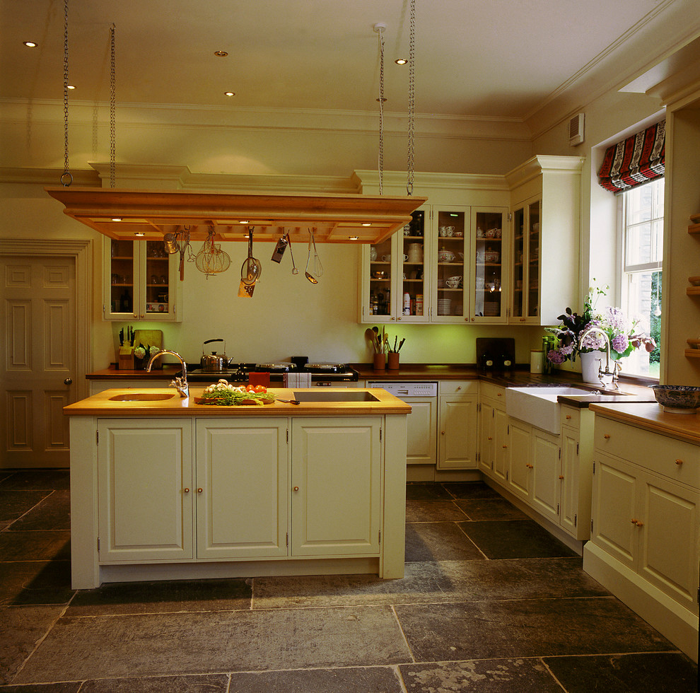 Bild på ett stort vintage vit vitt kök, med en rustik diskho, luckor med upphöjd panel, träbänkskiva, skiffergolv, en köksö och grått golv