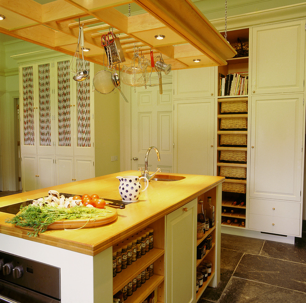 Inredning av ett klassiskt stort kök, med luckor med upphöjd panel, träbänkskiva, en rustik diskho, gula skåp, skiffergolv, en köksö och grått golv
