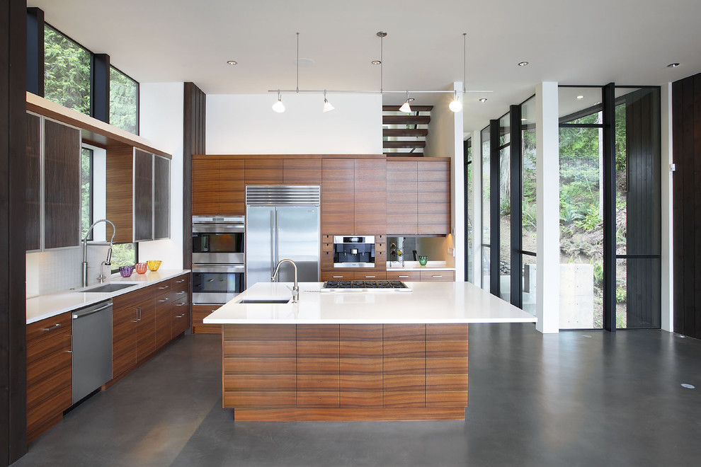 Inspiration for a modern kitchen in Seattle with stainless steel appliances, a submerged sink, flat-panel cabinets, dark wood cabinets, concrete flooring and grey floors.