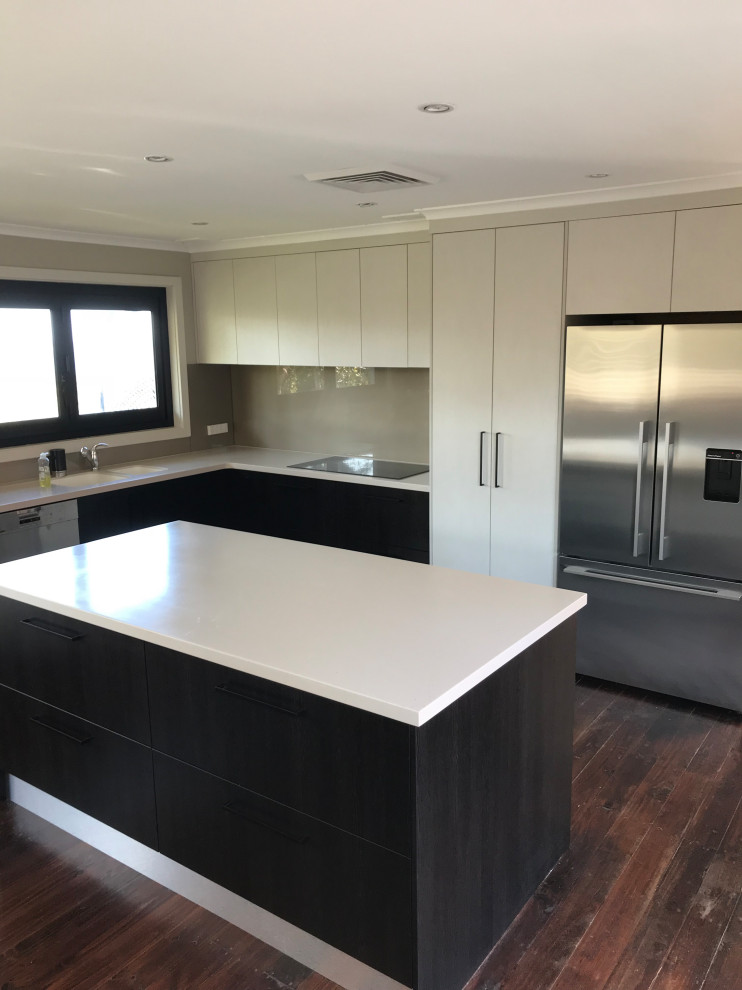 Mittelgroße Moderne Küche in U-Form mit flächenbündigen Schrankfronten, schwarzen Schränken, Glasrückwand, Küchengeräten aus Edelstahl und weißer Arbeitsplatte in Sydney