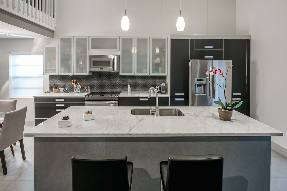 Exempel på ett mellanstort modernt linjärt kök, med en undermonterad diskho, släta luckor, marmorbänkskiva, grått stänkskydd, stänkskydd i glaskakel, rostfria vitvaror, klinkergolv i porslin och en köksö