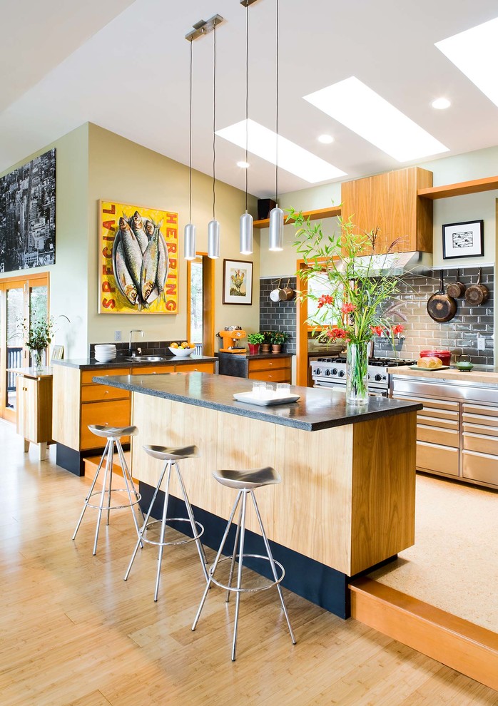 Cette photo montre une cuisine américaine moderne avec un plan de travail en béton, un électroménager en acier inoxydable, un sol en liège, îlot et un plan de travail gris.