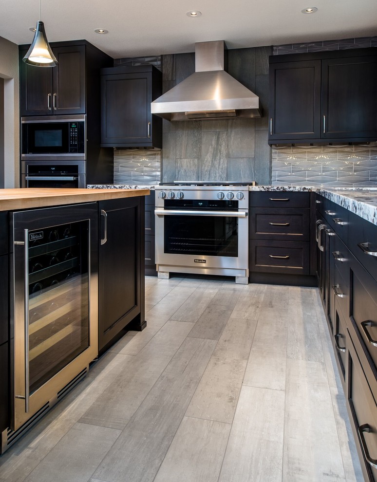 Idéer för att renovera ett mellanstort funkis grå grått kök, med en undermonterad diskho, släta luckor, skåp i mörkt trä, granitbänkskiva, grått stänkskydd, stänkskydd i porslinskakel, rostfria vitvaror, klinkergolv i porslin, en köksö och beiget golv