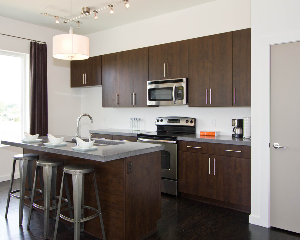 Foto de cocina actual con armarios con paneles lisos, puertas de armario de madera en tonos medios, electrodomésticos de acero inoxidable y barras de cocina
