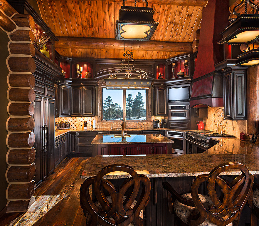 Esempio di un cucina con isola centrale classico con ante con bugna sagomata, ante in legno bruno, elettrodomestici da incasso e parquet scuro