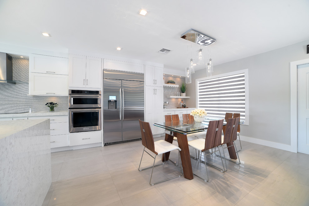 Inspiration for a large modern single-wall open concept kitchen remodel in Miami with shaker cabinets, white cabinets, quartz countertops, gray backsplash, porcelain backsplash, stainless steel appliances and an island
