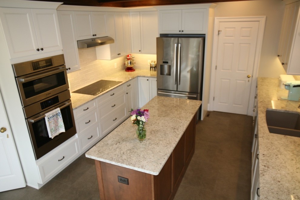 Exempel på ett mellanstort klassiskt flerfärgad flerfärgat kök, med en undermonterad diskho, luckor med profilerade fronter, vita skåp, granitbänkskiva, grått stänkskydd, stänkskydd i tunnelbanekakel, rostfria vitvaror, vinylgolv, en köksö och grått golv