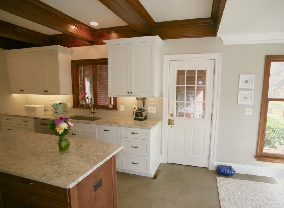 Klassisk inredning av ett mellanstort flerfärgad flerfärgat kök, med en undermonterad diskho, luckor med profilerade fronter, vita skåp, granitbänkskiva, grått stänkskydd, stänkskydd i tunnelbanekakel, rostfria vitvaror, vinylgolv, en köksö och grått golv