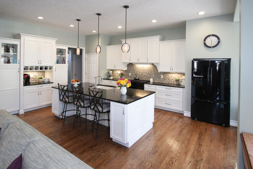 Example of a classic dark wood floor open concept kitchen design in Other with a single-bowl sink, shaker cabinets, white cabinets, quartz countertops, ceramic backsplash, black appliances and an island