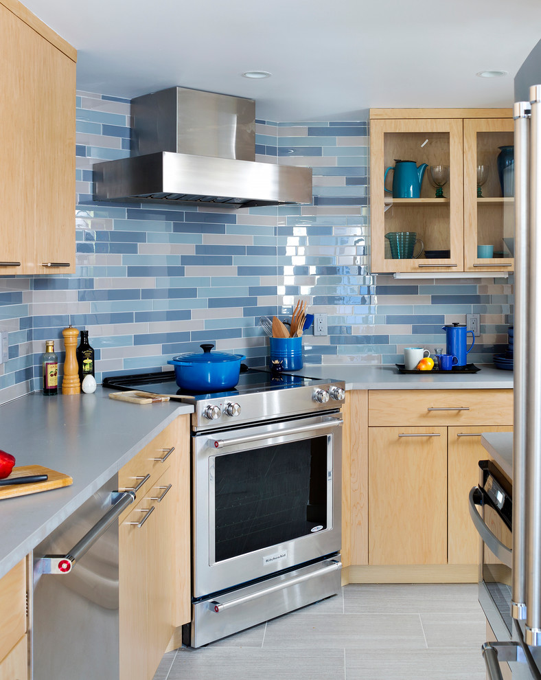 Идея дизайна: отдельная, угловая кухня среднего размера в современном стиле с плоскими фасадами, светлыми деревянными фасадами, синим фартуком, фартуком из плитки кабанчик, техникой из нержавеющей стали и серым полом без острова
