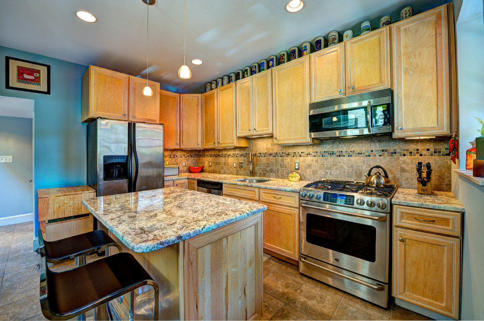 Small eclectic l-shaped ceramic tile enclosed kitchen photo in DC Metro with an undermount sink, recessed-panel cabinets, light wood cabinets, granite countertops, brown backsplash, stone tile backsplash, stainless steel appliances and an island