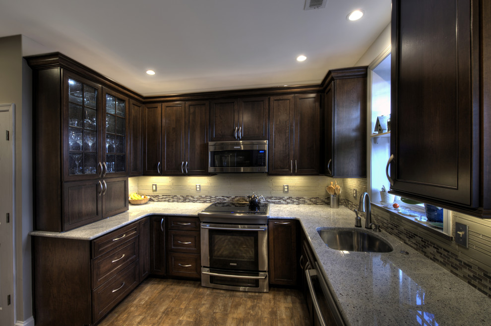 Example of a small classic u-shaped ceramic tile enclosed kitchen design in DC Metro with an undermount sink, recessed-panel cabinets, dark wood cabinets, granite countertops, multicolored backsplash, glass tile backsplash, stainless steel appliances and no island