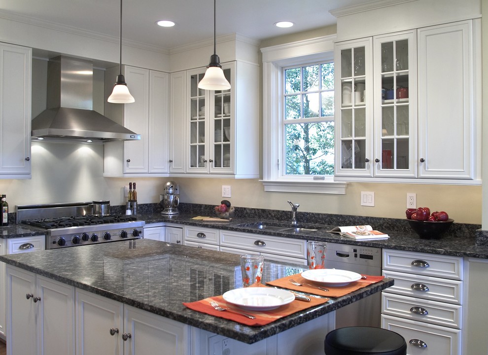 Example of a large eclectic u-shaped eat-in kitchen design in DC Metro with an undermount sink, recessed-panel cabinets, light wood cabinets, stainless steel appliances, an island and solid surface countertops