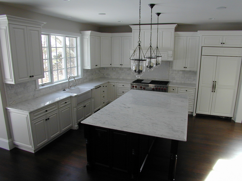 Inspiration for a large timeless l-shaped dark wood floor and brown floor eat-in kitchen remodel in Boston with a farmhouse sink, raised-panel cabinets, white cabinets, marble countertops, gray backsplash, marble backsplash, paneled appliances and an island
