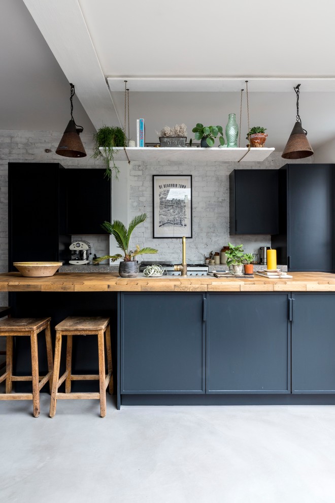 Идея дизайна: прямая кухня среднего размера в стиле лофт с плоскими фасадами, синими фасадами, деревянной столешницей, бетонным полом, островом, серым полом и бежевой столешницей