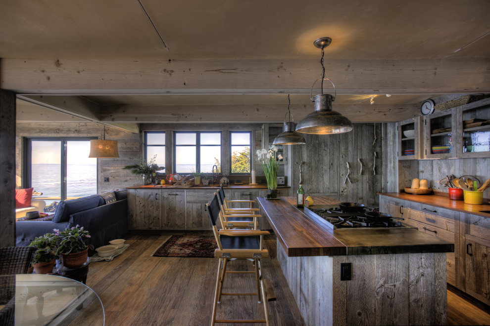 Rustic open plan kitchen in Santa Barbara with glass-front cabinets and wood worktops.