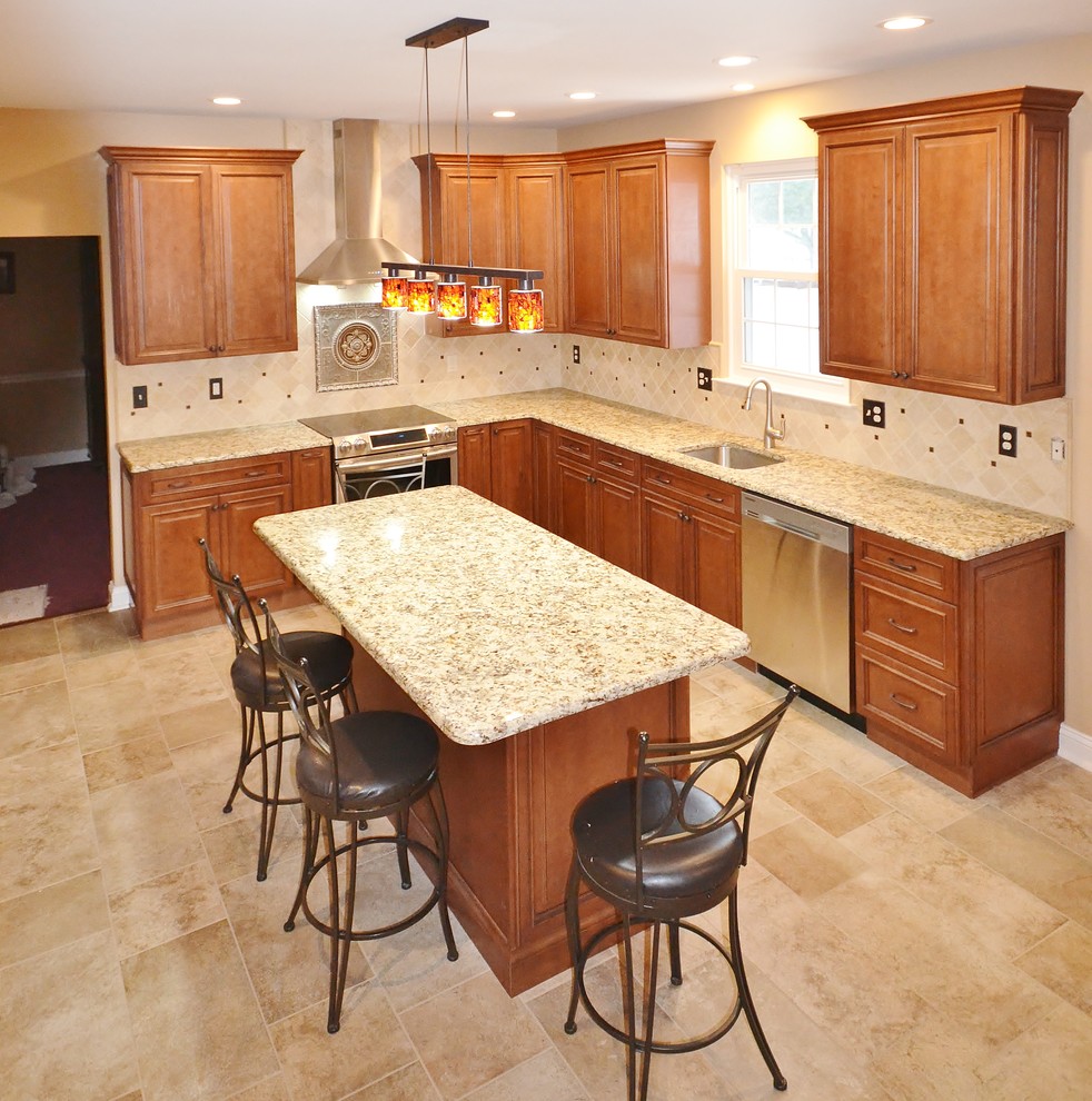 Inspiration for a large timeless l-shaped ceramic tile eat-in kitchen remodel in Philadelphia with an undermount sink, raised-panel cabinets, medium tone wood cabinets, granite countertops, beige backsplash, ceramic backsplash, stainless steel appliances and an island