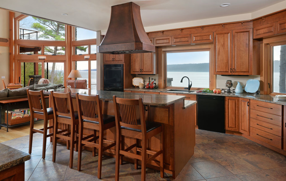 На фото: кухня-гостиная в стиле рустика с фасадами с выступающей филенкой, темными деревянными фасадами, черной техникой, островом и окном
