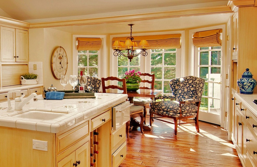 На фото: кухня в классическом стиле с столешницей из плитки, шторами на окнах и эркером