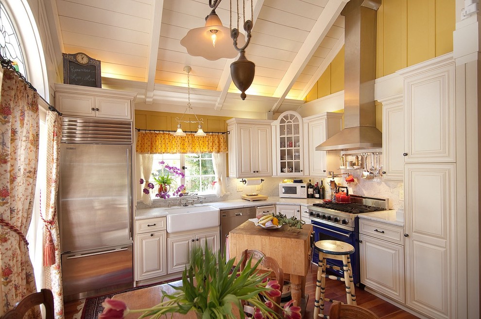 Foto på ett litet vintage l-kök, med färgglada vitvaror, en rustik diskho, luckor med profilerade fronter, vita skåp, marmorbänkskiva, vitt stänkskydd, stänkskydd i sten, mellanmörkt trägolv och en köksö