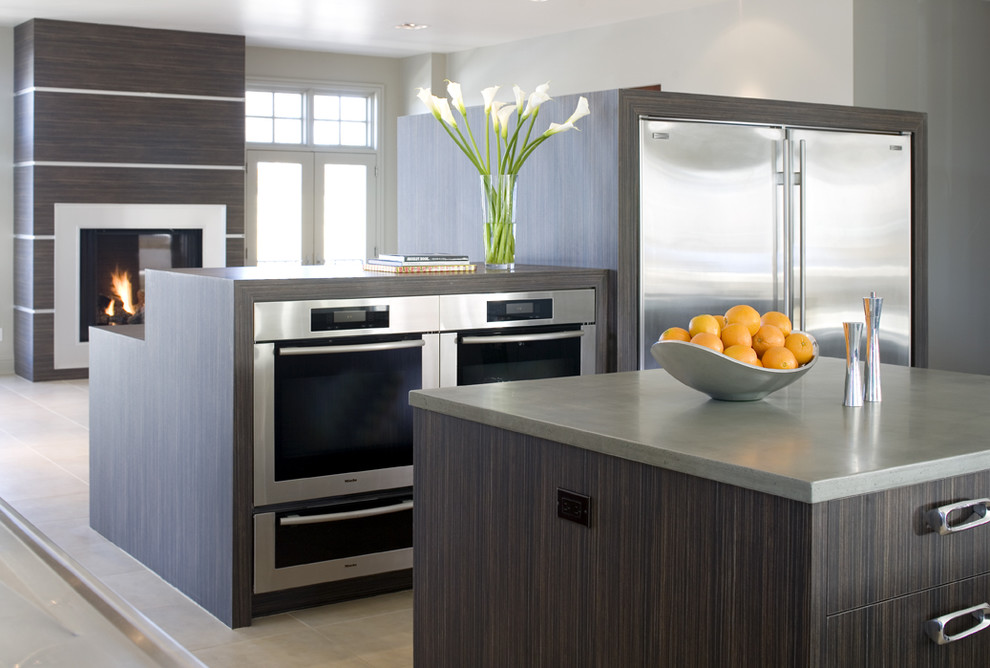 Example of a minimalist open concept kitchen design in Denver with stainless steel appliances, flat-panel cabinets and dark wood cabinets