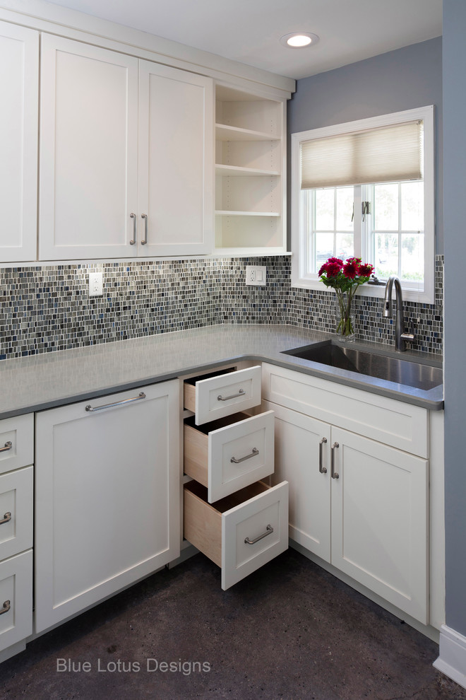 Example of a small trendy u-shaped concrete floor and gray floor eat-in kitchen design in Philadelphia with an undermount sink, shaker cabinets, white cabinets, quartz countertops, multicolored backsplash, glass tile backsplash and stainless steel appliances