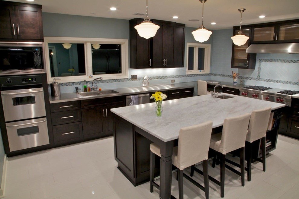 Eat-in kitchen - mid-sized contemporary u-shaped porcelain tile eat-in kitchen idea in Atlanta with a double-bowl sink, shaker cabinets, dark wood cabinets, stainless steel countertops, blue backsplash, subway tile backsplash, stainless steel appliances and an island