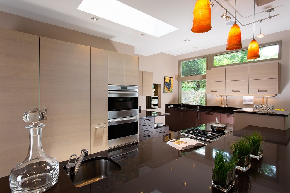 This is an example of a large contemporary kitchen in Atlanta with a submerged sink, flat-panel cabinets, beige cabinets, granite worktops, porcelain flooring and an island.